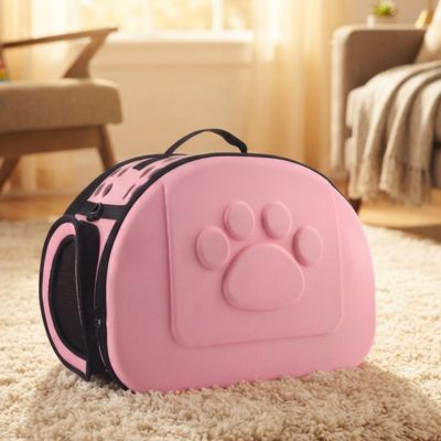 Chat sac transport pliable de couleur  rose sur un tapis.