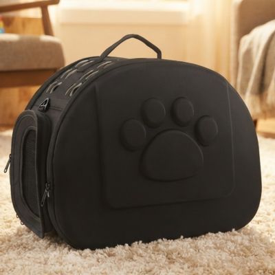 Chat-sac-transport-sac-noir-pose-sur-un-tapis-pres-de-la-cheminee.