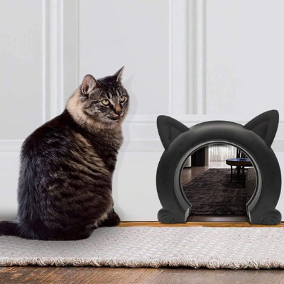 Chat tigré assis à côté d'une chatière noire design moderne.
