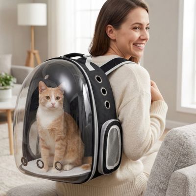 Femme souriante portant un sac à chat transport Cosmonaute noir à hublot.