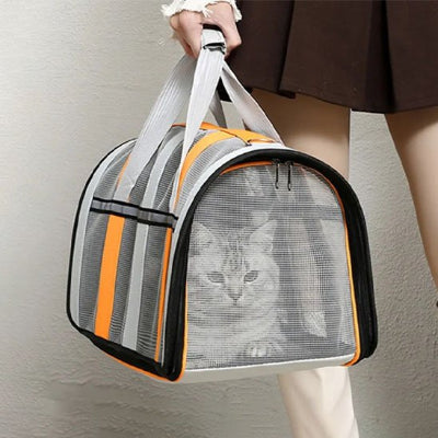 Femme tient un sac transport chat en maille rayée orange chat visible
