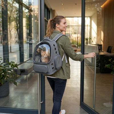 Sac à dos chat gris avec hublot porté par une femme entrant dans un bâtiment