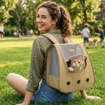 Sac à dos chat marron au parc avec une femme souriante