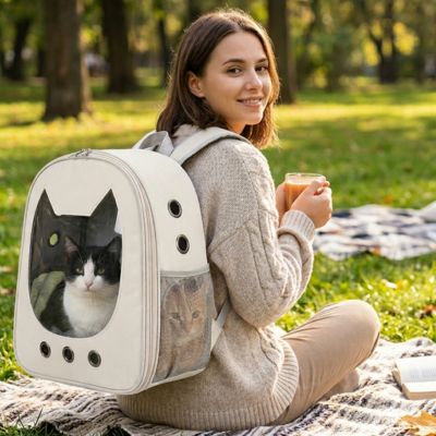 Sac à dos pour chat beige avec hublot au parc.