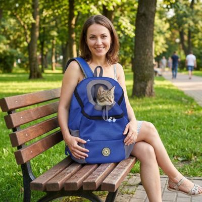 Sac à dos transport chat bleu avec une femme souriante au parc.

