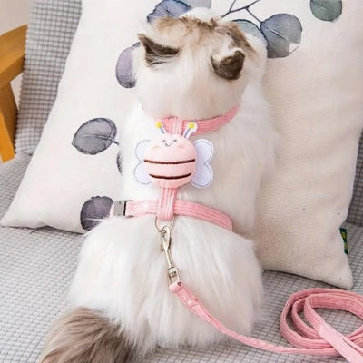 Un chat moelleux en harnais pour chat rose avec une abeille a l arriere